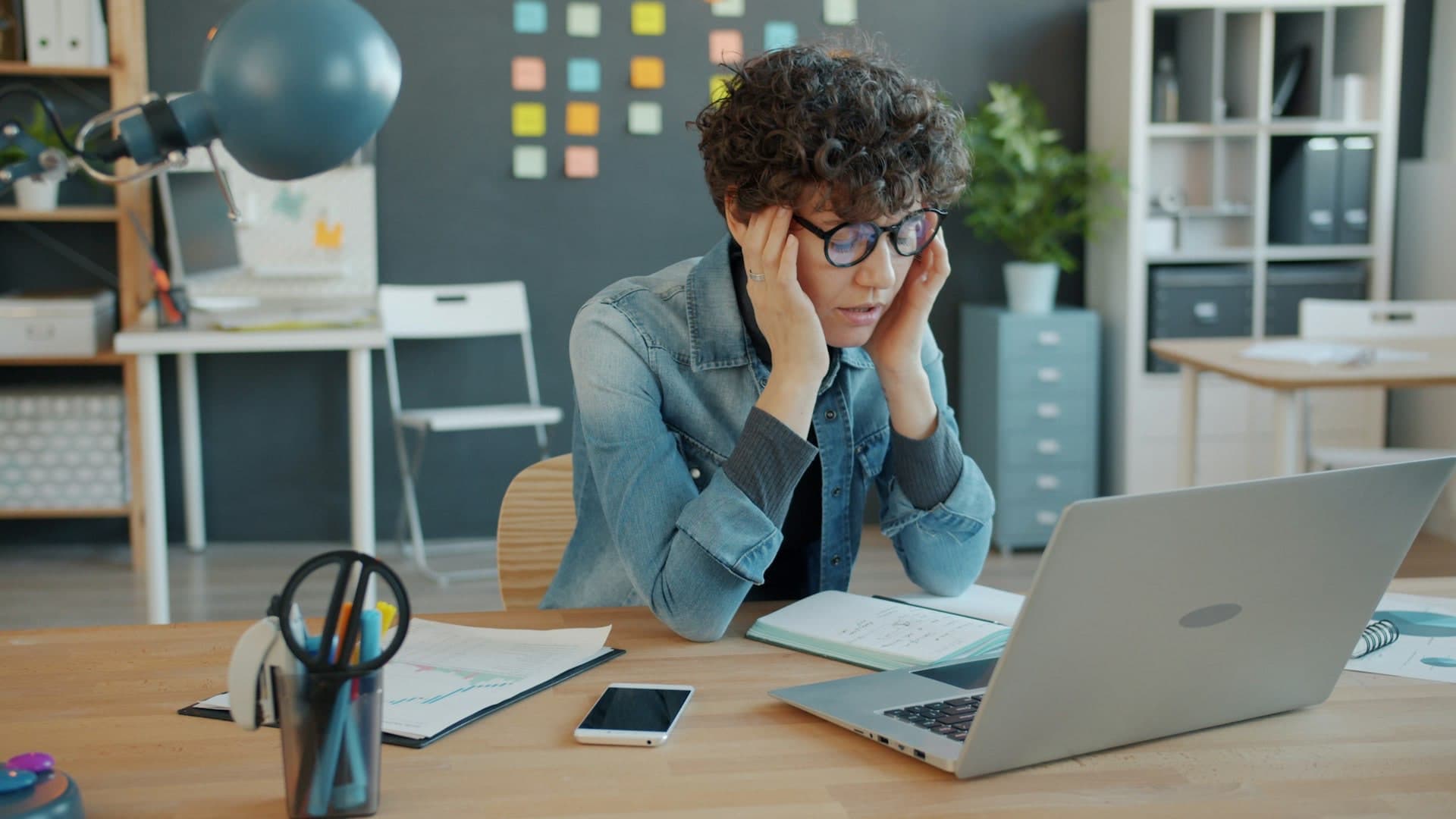 Persona estresada frente a su laptop revisando malas noticias